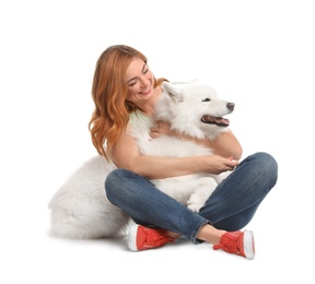 Beautiful woman hugging her dog on white background