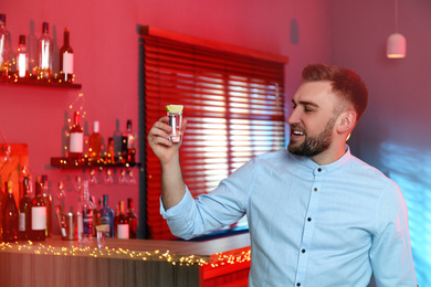 Photo of Young man with Mexican Tequila shot in bar