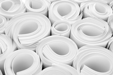 Rolled white paper sheets as background, closeup