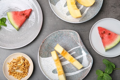 Photo of Flat lay composition with pieces of fresh melon and watermelon on table