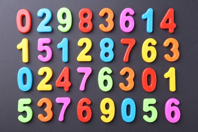 Photo of Colorful numbers on dark gray background, flat lay