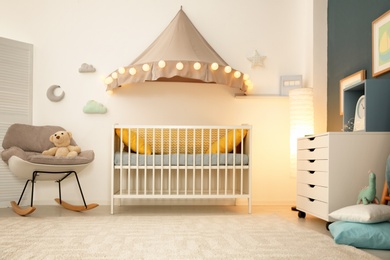 Photo of Stylish baby room interior with crib