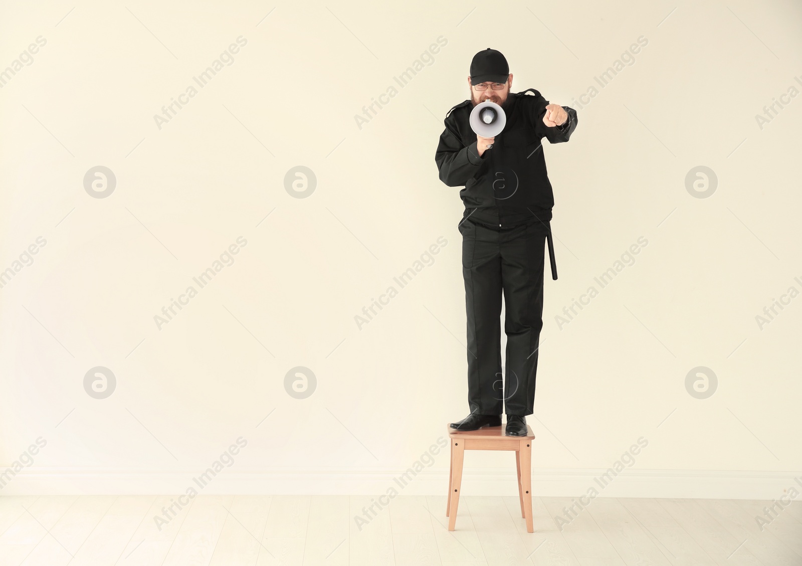 Photo of Security guard shouting into megaphone indoors