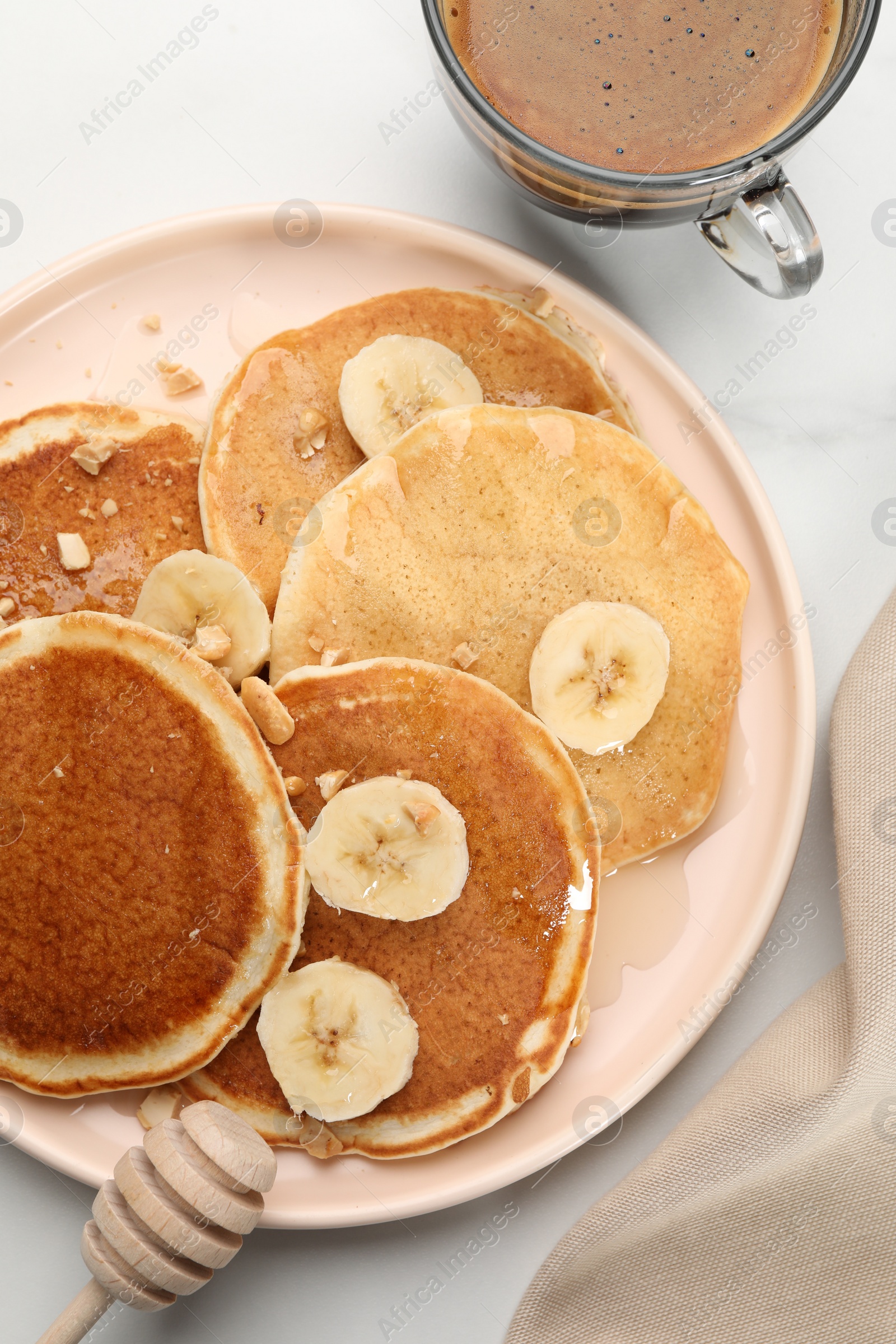 Photo of Tasty pancakes with sliced banana served on white marble table, flat lay