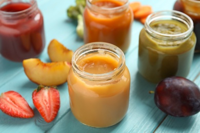 Photo of Healthy baby food and ingredients on light blue wooden table