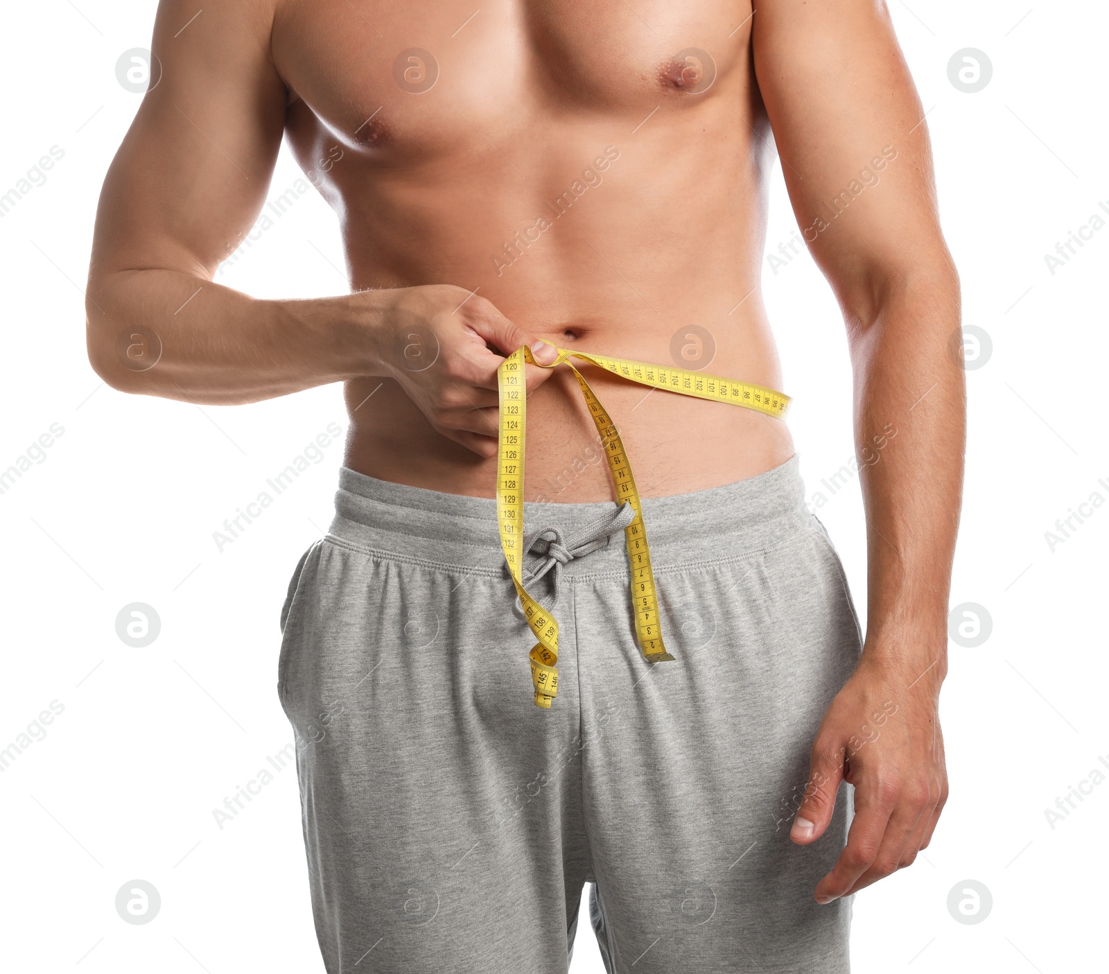 Photo of Young man with slim body using measuring tape on white background, closeup view