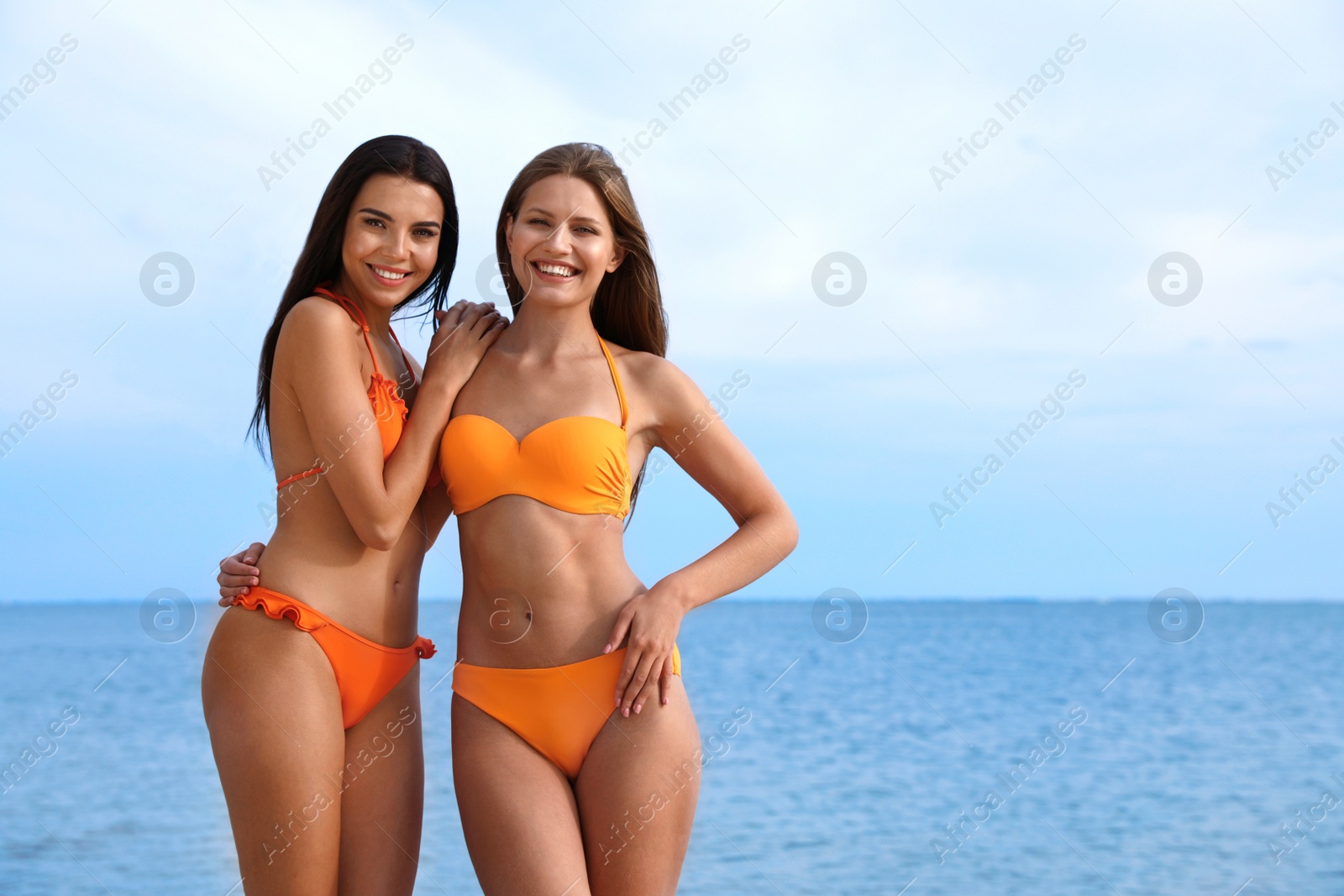 Photo of Young couple in bikini spending time together on beach