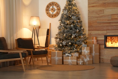 Stylish room interior with beautiful Christmas tree and gift boxes