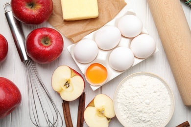 Photo of Traditional English apple pie ingredients on white wooden table, flat lay