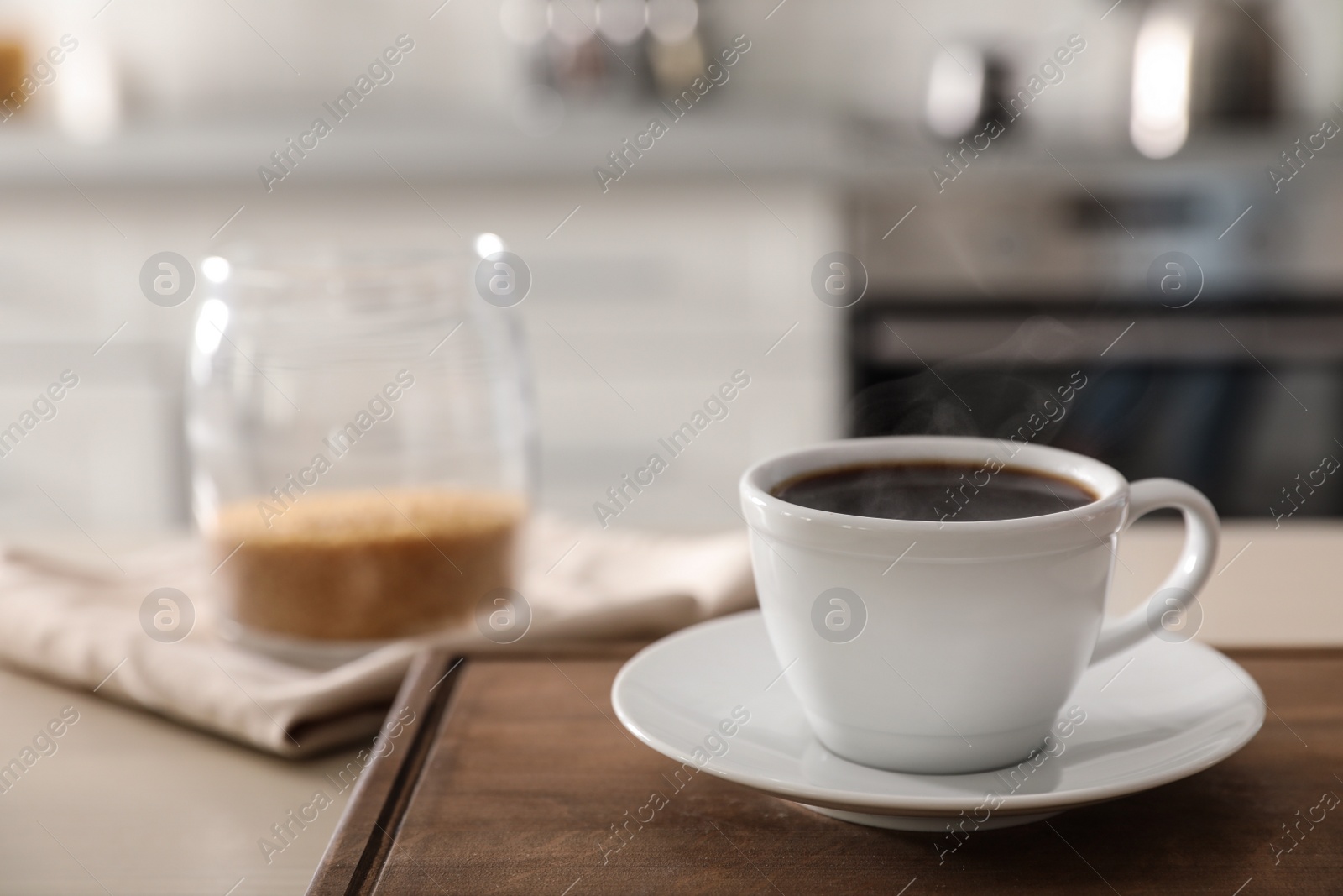 Photo of Cup of fresh coffee on table in kitchen