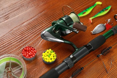 Fishing tackle. Reel, rod, lures and different baits on wooden table