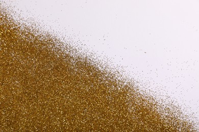 Photo of Shiny golden glitter on white background, top view