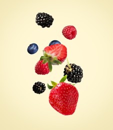 Image of Many different fresh berries falling on beige background