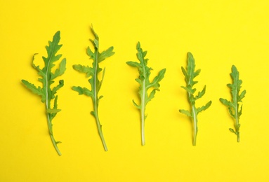 Photo of Fresh arugula on yellow background, flat lay