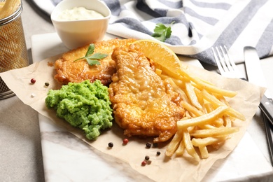 Photo of British traditional fish and potato chips on table