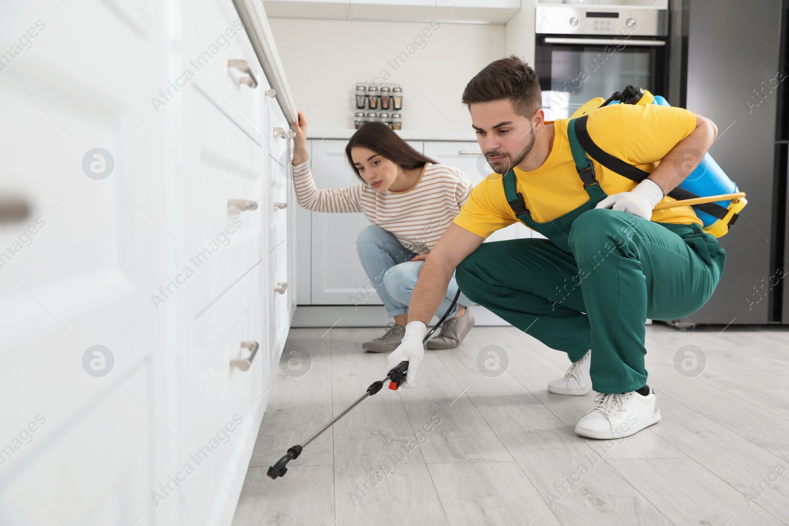 Photo of Woman showing insect traces to pest control worker in kitchen