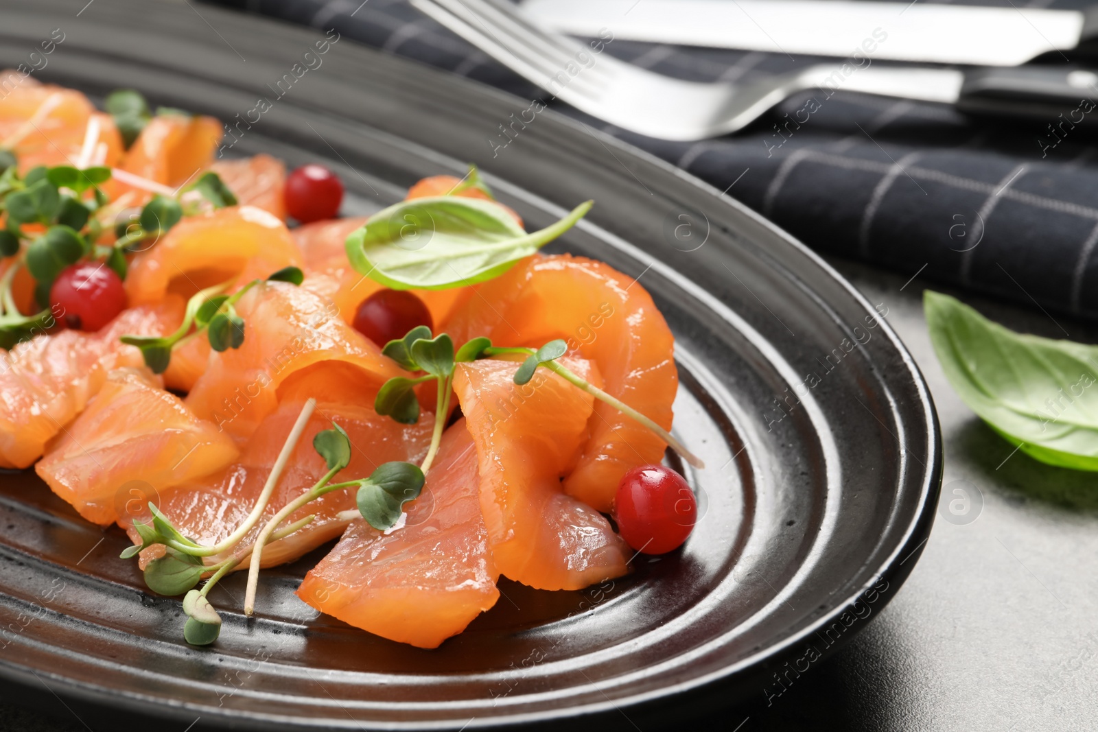 Photo of Delicious salmon carpaccio served on grey table, closeup