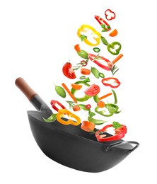 Different tasty ingredients falling into wok on white background