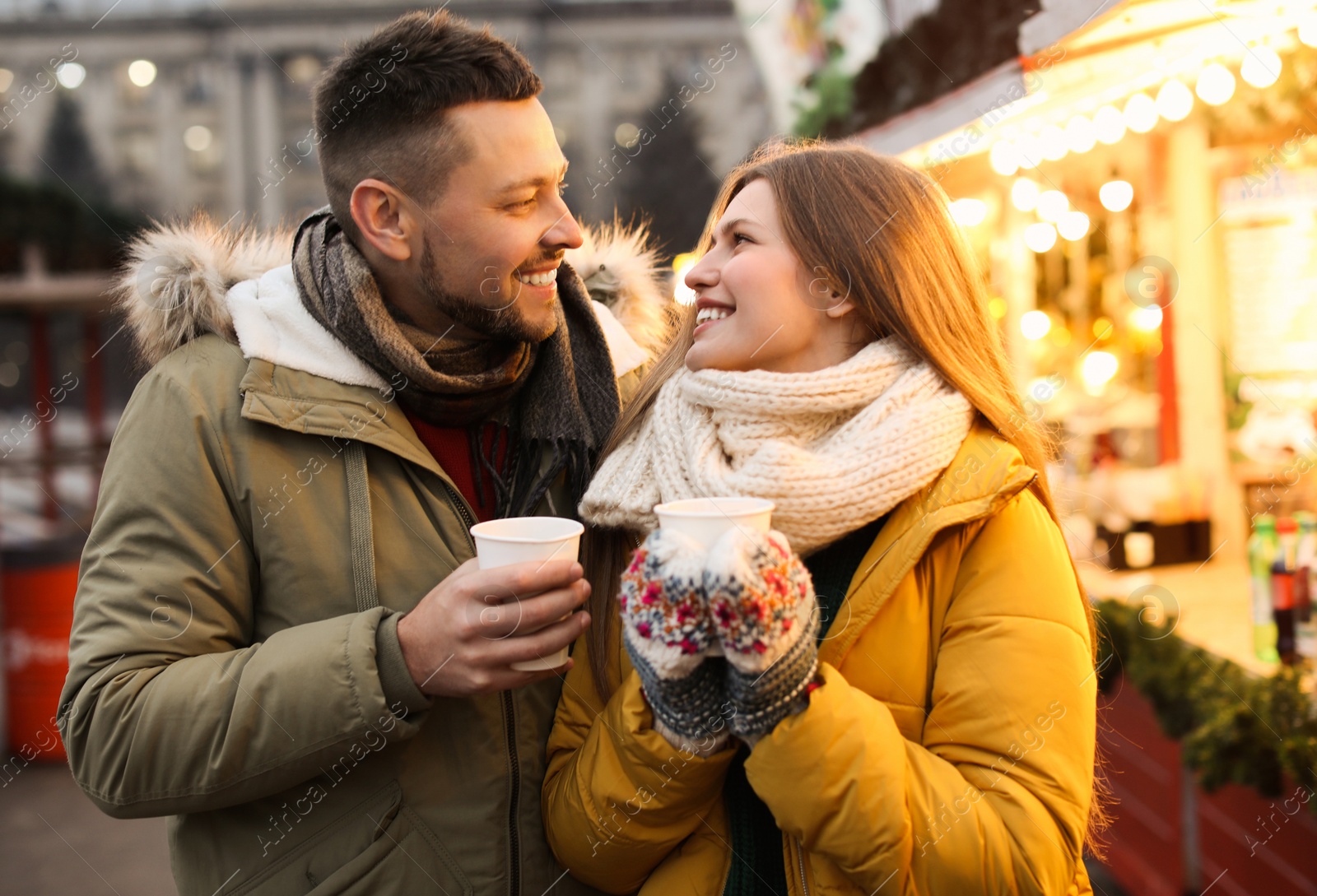 Photo of Happy couple with mulled wine at winter fair