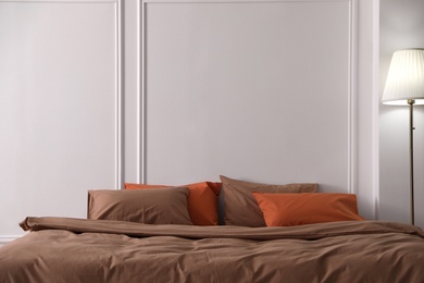 Bed with orange and brown linens in stylish room