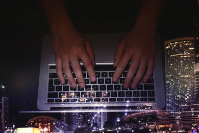 Double exposure of male programmer using laptop and cityscape, top view 