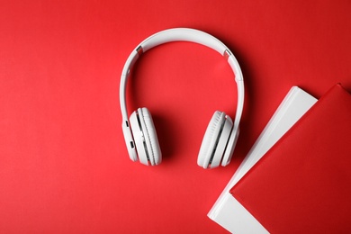 Photo of Modern headphones with hardcover books on color background, top view