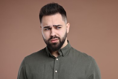 Portrait of sad man on brown background