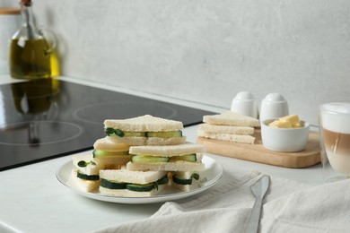 Tasty sandwiches with cucumber, butter and microgreens on white table in kitchen