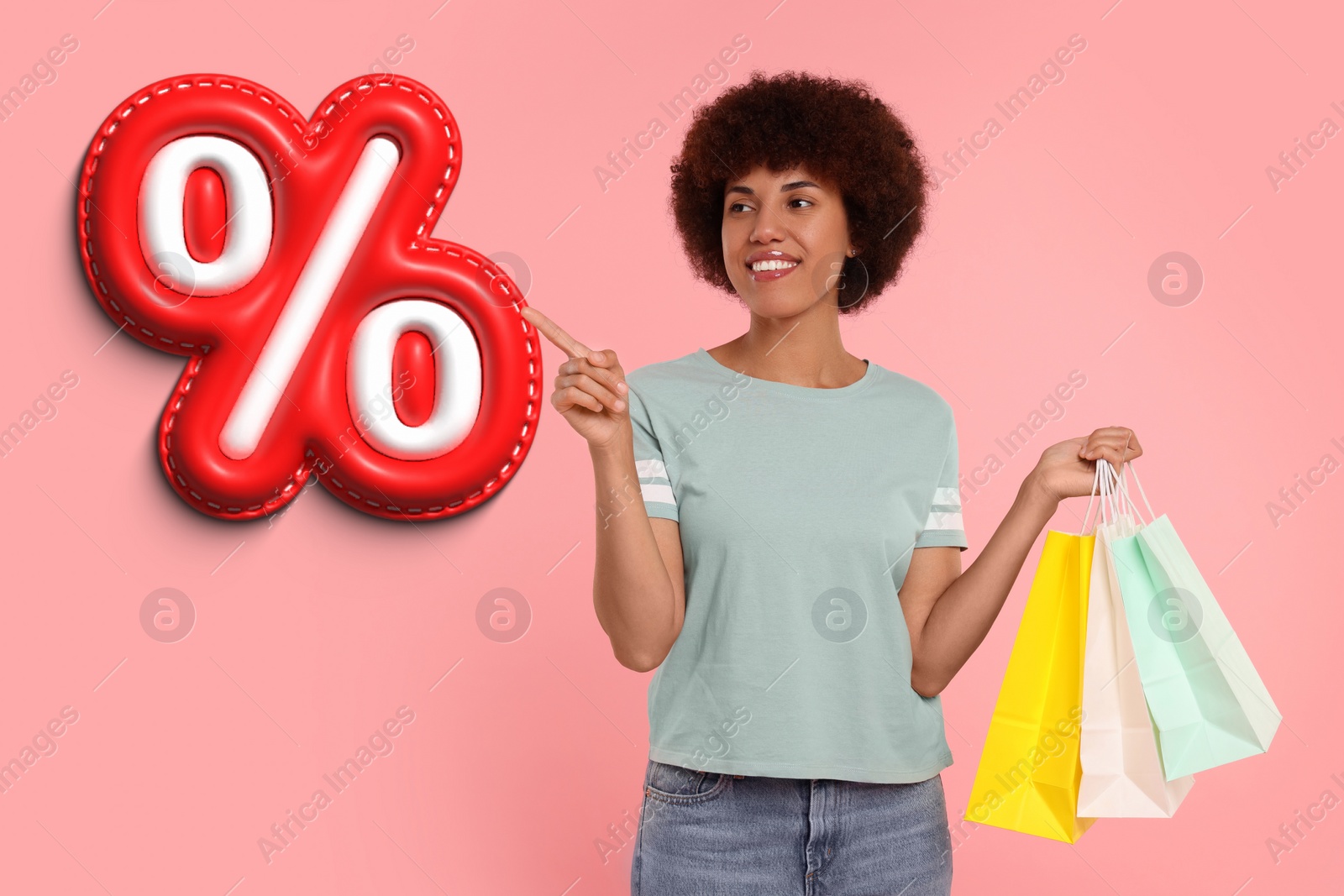 Image of Discount offer. Happy woman with paper shopping bags pointing at illustration of percent sign on pink background