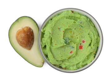 Bowl of delicious guacamole and fresh avocado isolated on white, top view