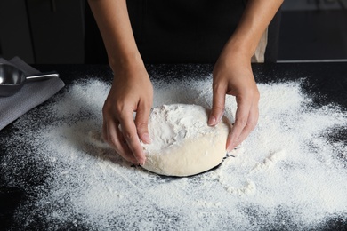 Photo of Woman making dough for pastry on table