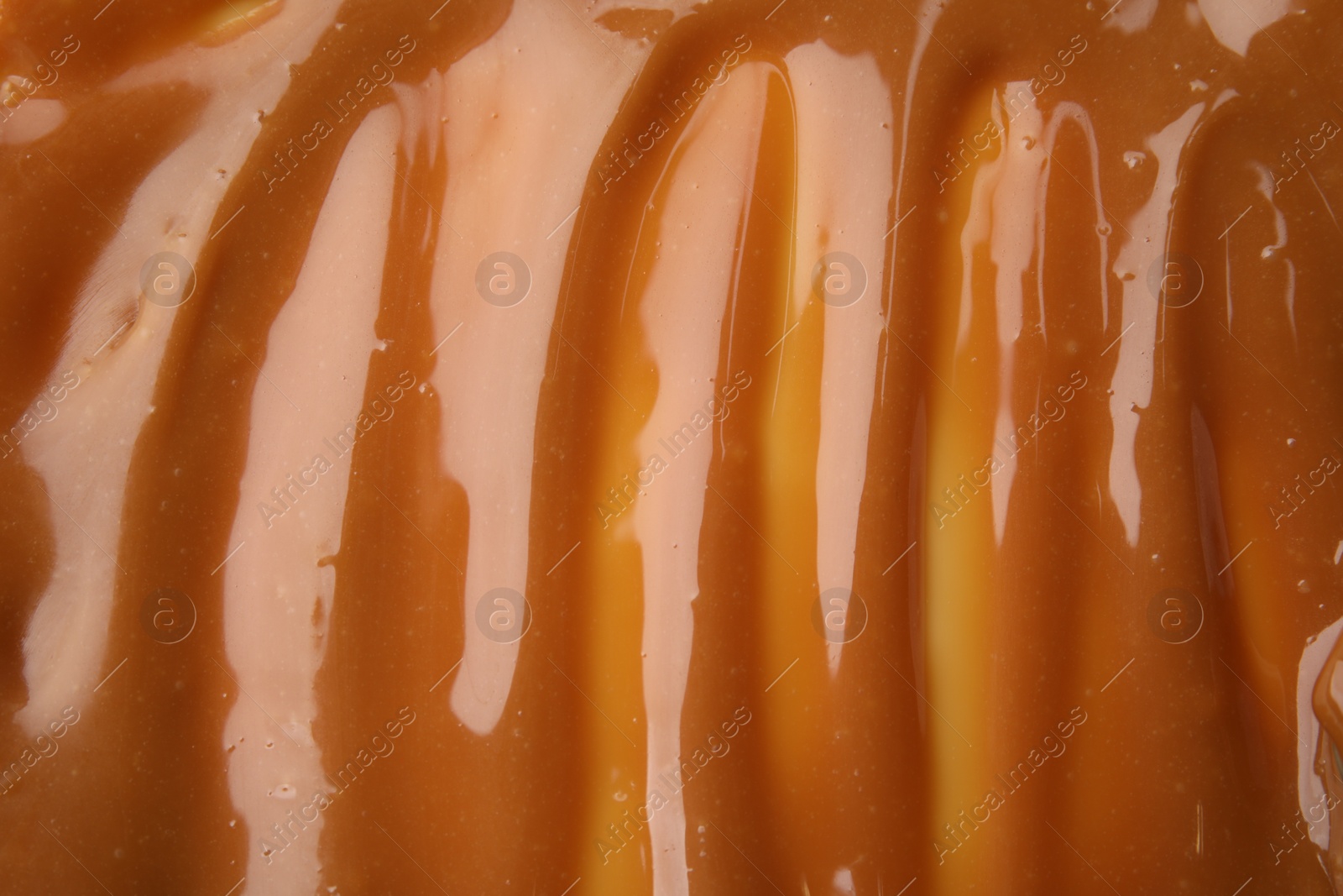 Photo of Delicious caramel sauce with sea salt as background, closeup