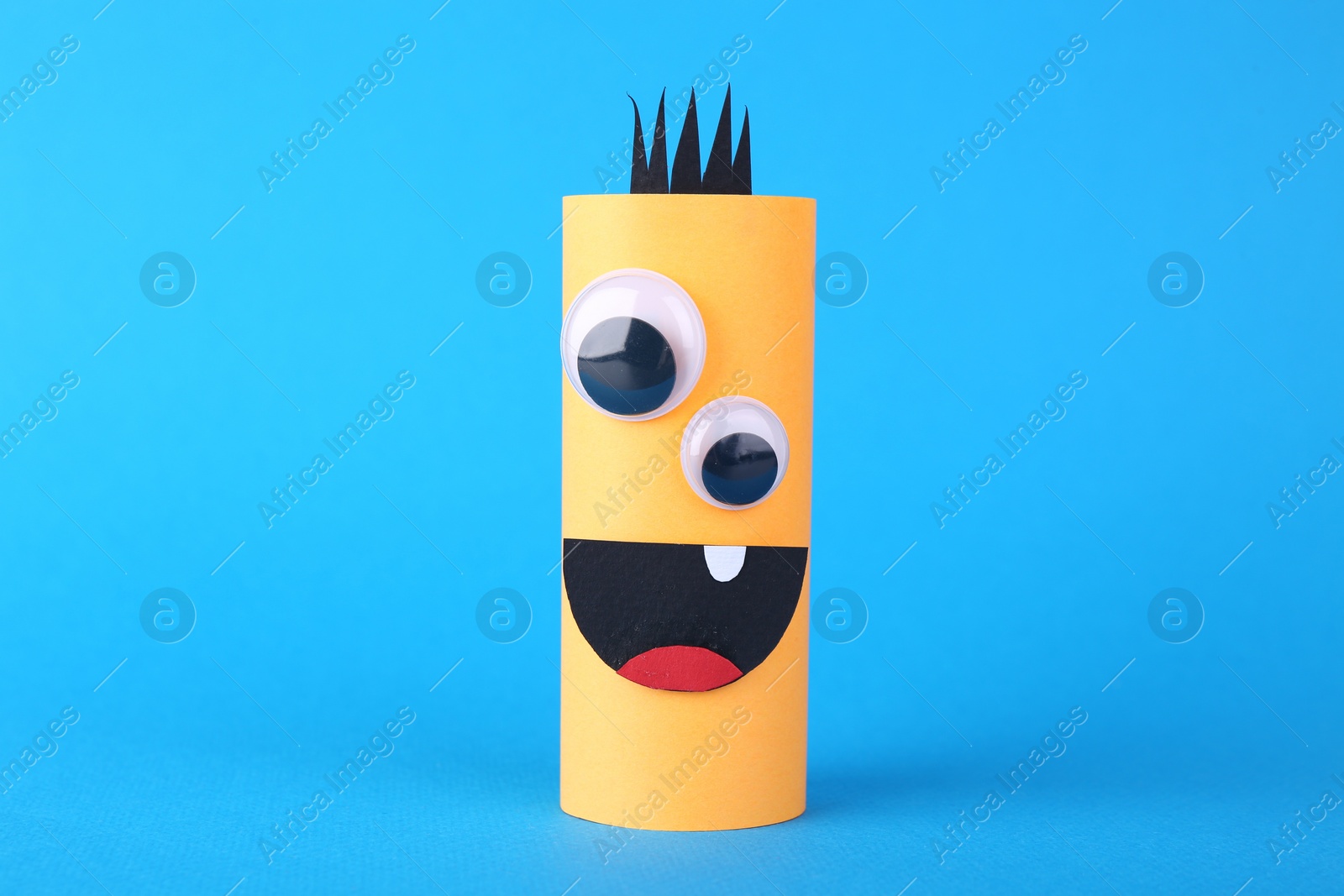 Photo of Spooky paper monster on light blue background. Handmade Halloween decoration