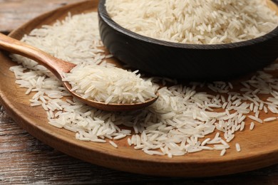 Photo of Raw basmati rice on wooden table, closeup