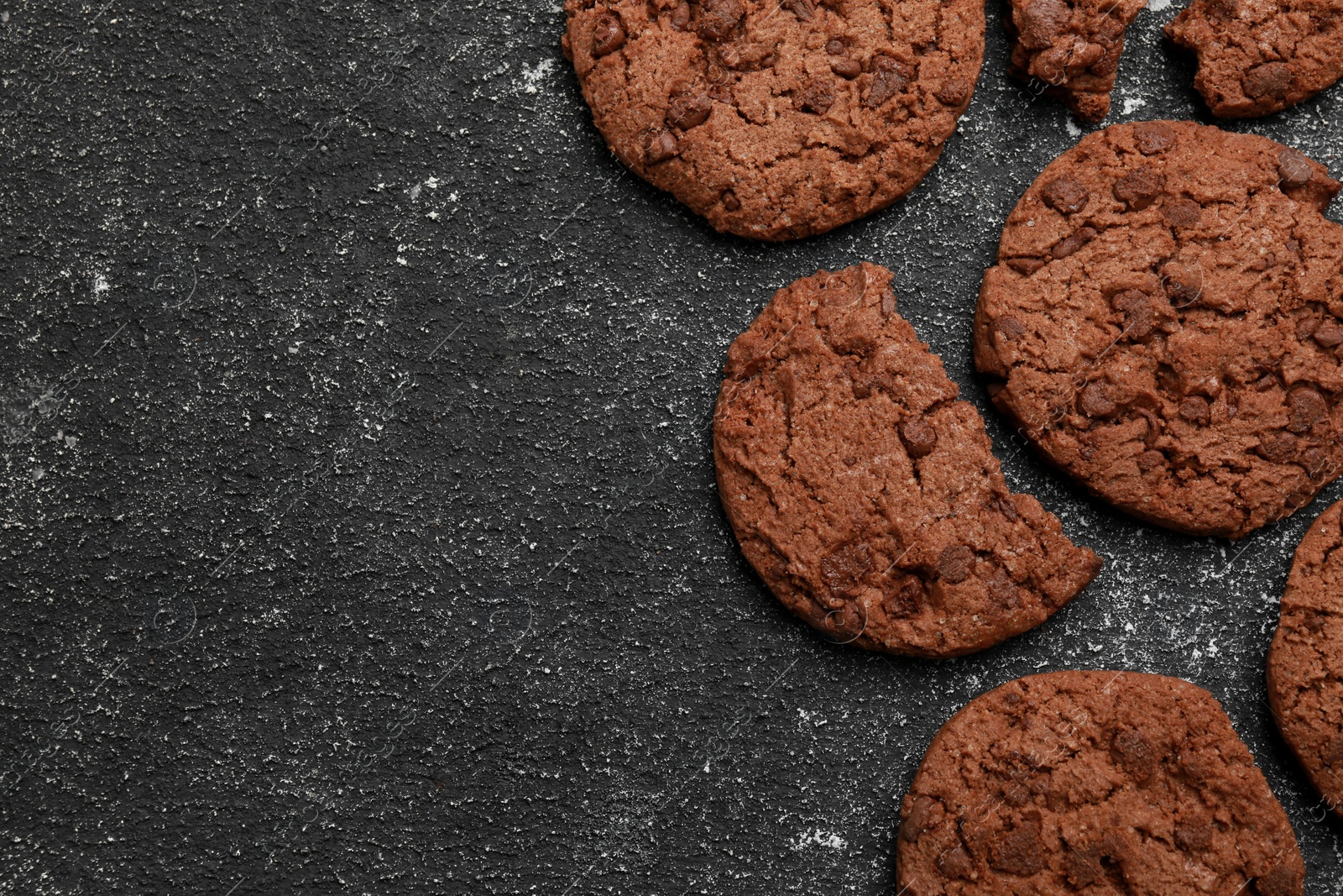 Photo of Tasty chocolate cookies on grey textured table, flat lay. Space for text