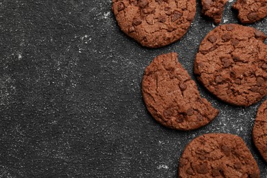 Tasty chocolate cookies on grey textured table, flat lay. Space for text