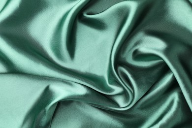 Photo of Crumpled green silk fabric as background, top view