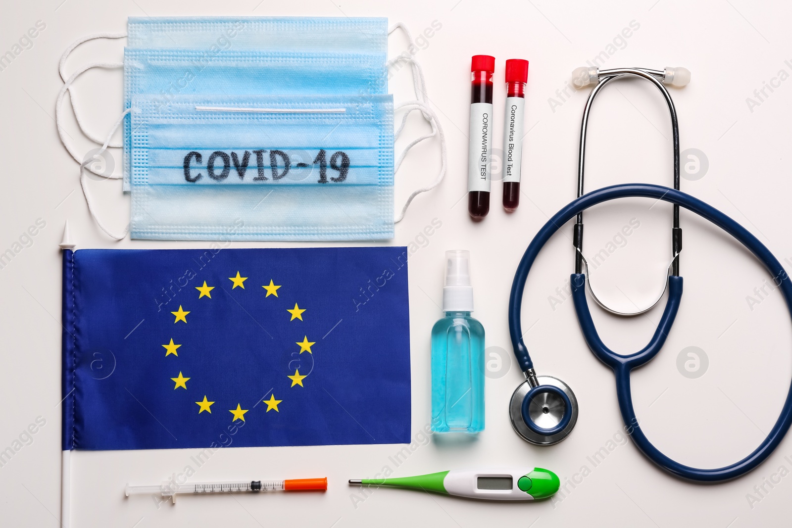 Photo of Flat lay composition with European Union flag and protective masks on white background. Coronavirus outbreak