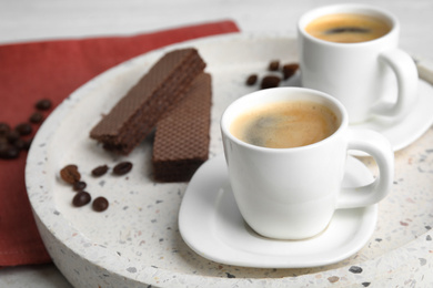 Photo of Delicious coffee and wafers for breakfast on tray, closeup. Space for text