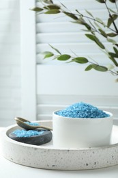 Photo of Blue sea salt on white table indoors, space for text