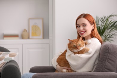 Photo of Happy woman with her cute cat in armchair at home. Space for text