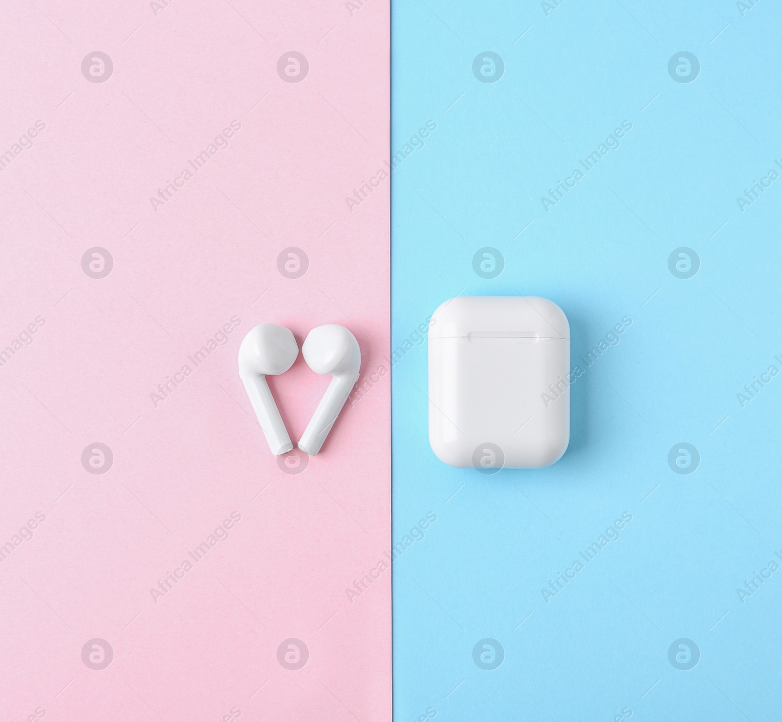 Photo of Modern wireless earphones and charging case on color background, flat lay