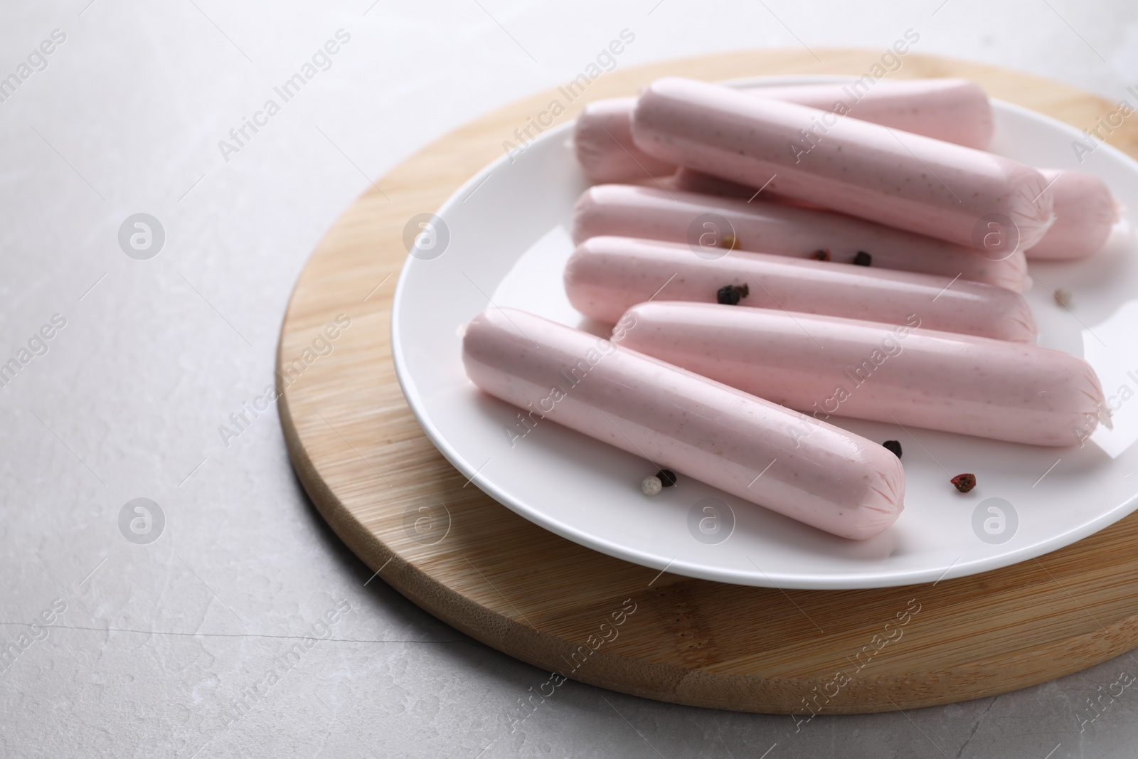 Photo of Vegan sausages with spices on light grey table, space for text