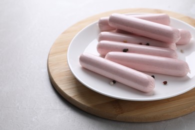 Photo of Vegan sausages with spices on light grey table, space for text