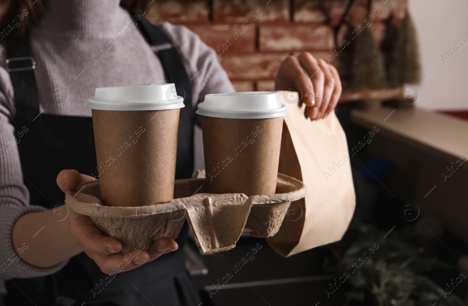 Photo of Barista with takeaway coffee and dessert in cafe, closeup