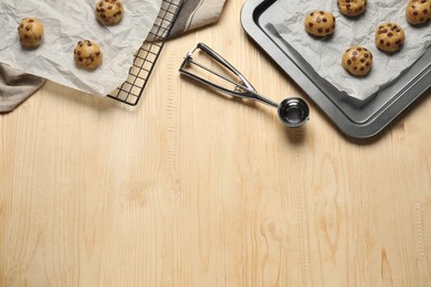 Photo of Uncooked chocolate chip cookies on wooden table, top view. Space for text