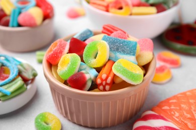 Bowl of tasty colorful jelly candies on white table, closeup