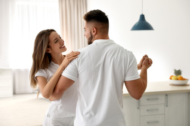 Photo of Lovely young couple dancing together at home