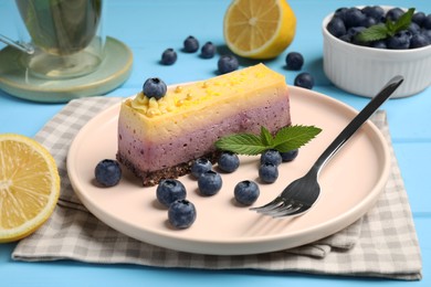 Delicious cheesecake with blueberry, lemon and mint on light blue wooden table
