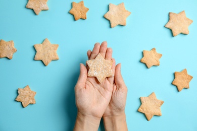 Photo of Woman holding tasty homemade Christmas cookie on color background